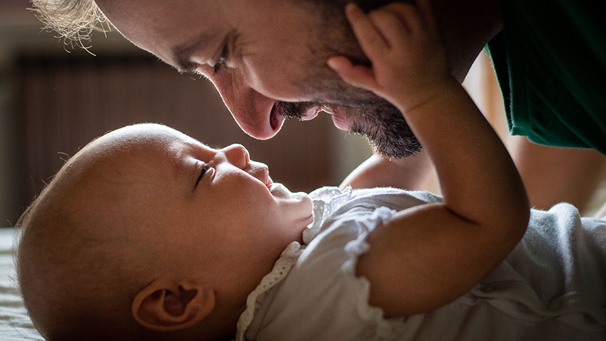 A close-up with a father looking at a baby.