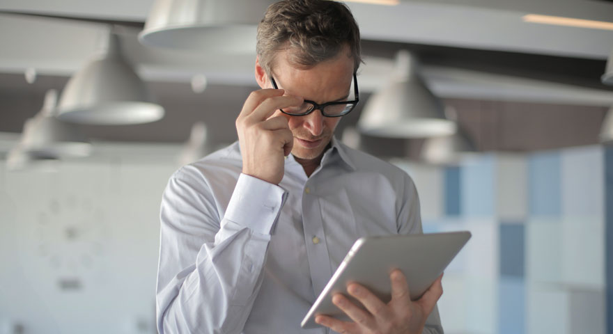 A man looking down on a tablet